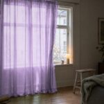 Gardin af organza i lavendel foran et vindue